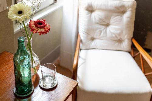 uma mesa com uma garrafa verde e um vaso com flores em Locanda La Concia em Reggio Emilia