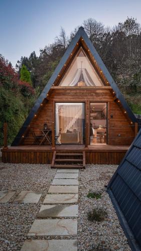 Cabaña de madera con ventana grande en la parte delantera en Casas da Madrinha en Arcos de Valdevez