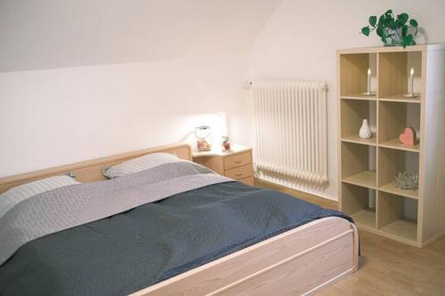 ein Schlafzimmer mit einem Bett und einem Bücherregal in der Unterkunft FERIENWOHNUNG "Deichort" Meppen in Meppen