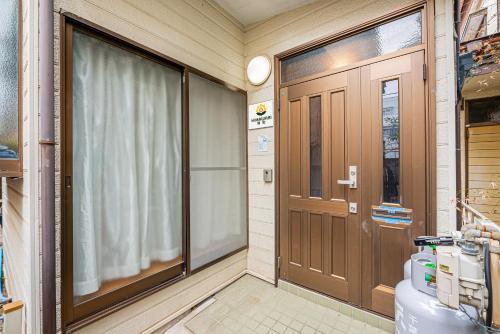 une salle de bain avec toilettes et porte en bois dans l'établissement Himawari, à Tokyo