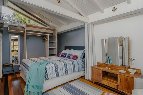 1 dormitorio con cama, escritorio y ventana en Studio Thai na praia en Imbituba
