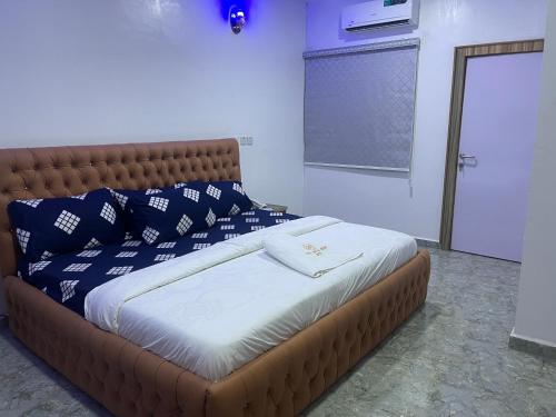 łóżko z biało-niebieskimi poduszkami w pokoju w obiekcie First Royal Beam Hotel w mieście Makurdu