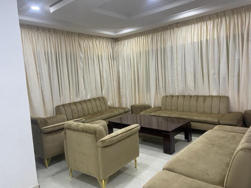 a living room with couches and tables and curtains at First Royal Beam Hotel in Makurdu