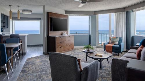 Sala de estar con sofá, TV y mesa en Marriott Hutchinson Island Beach Resort, Golf & Marina, en Stuart