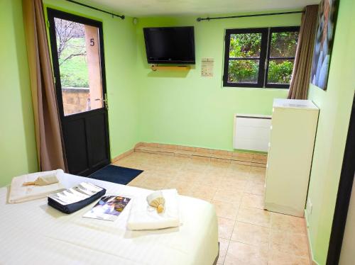 a room with a bed and a tv on the wall at La Maison de Tari in Vitrac