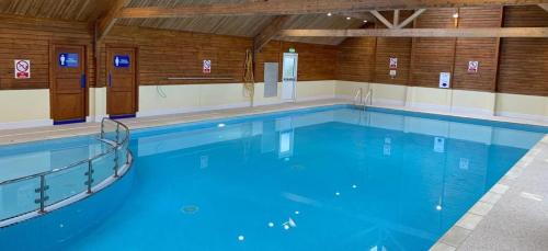 a large indoor swimming pool with blue water at Barmouthbay209 in Barmouth