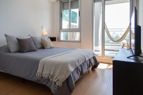 a bedroom with a bed and a large window at Panoramic view Palermo - Pool & BBQ in Buenos Aires