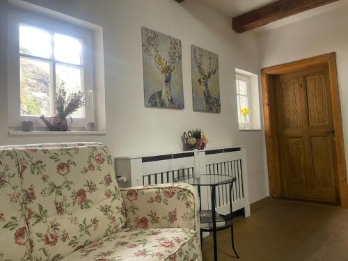 a living room with a chair and a table at Pension Soutěsky in Hřensko