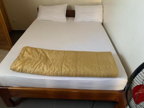 a bed with a gold blanket on top of it at Studio liberté 2 in Dakar