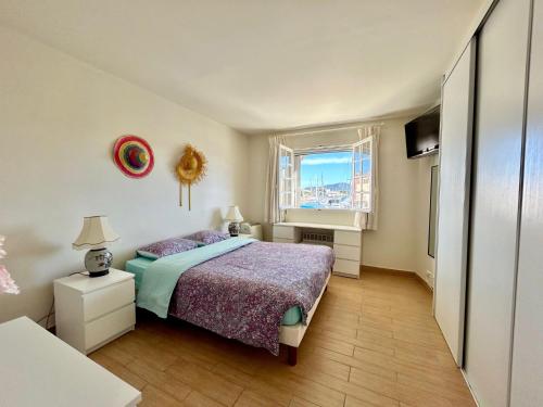 une chambre avec un lit et une fenêtre dans l'établissement Port Grimaud le Grand Pin, à Grimaud