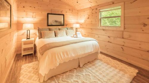 een slaapkamer met een bed in een houten kamer bij Romantic spot! Huge deck with outdoor soaking tub in Cosby