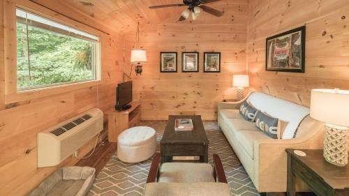 een woonkamer met een bank en een tv in een huisje bij Romantic spot! Huge deck with outdoor soaking tub in Cosby