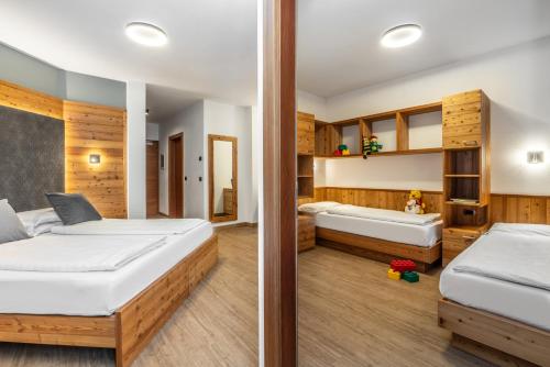 a bedroom with two beds and a bathroom at Family Hotel Adriana in Ledro