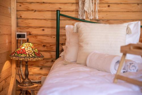 un dormitorio con una cama y una lámpara junto a ella en Wooden House Apartments en Kaláthenai