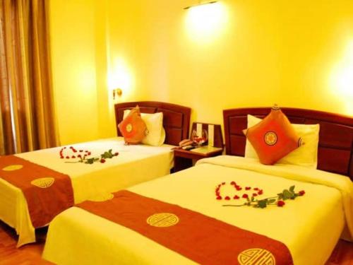 ein Hotelzimmer mit 2 Betten mit Blumen darauf in der Unterkunft Nhà nghỉ Vĩnh Phát Nội Bài in Sóc Sơn