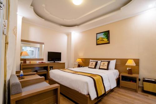 a bedroom with a bed and a desk and a television at Nhà nghỉ Vĩnh Phát Nội Bài in Sóc Sơn