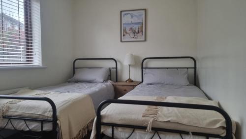 two beds sitting next to each other in a bedroom at Rotherham Kimberworth home from home with WIFi and Driveway in Kimberworth