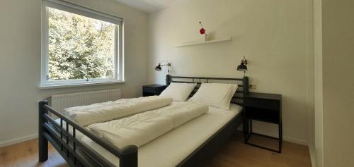 two beds in a bedroom with a window at Bungalowpark Bij de Bronnen in Nutter