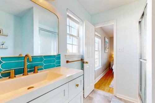 een badkamer met een wastafel en een spiegel bij The Hornet's Nest in Surf City