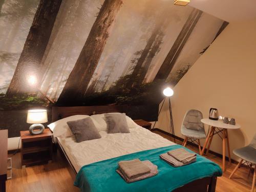 una camera da letto con un letto e un dipinto sul muro di Dworek Zaporów a Górecko Kościelne