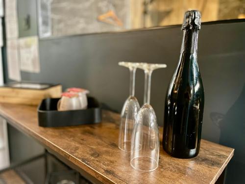 une bouteille et deux verres à vin assis sur une table dans l'établissement Sleep'In Cities Le Saphir Balnéo, à Albi