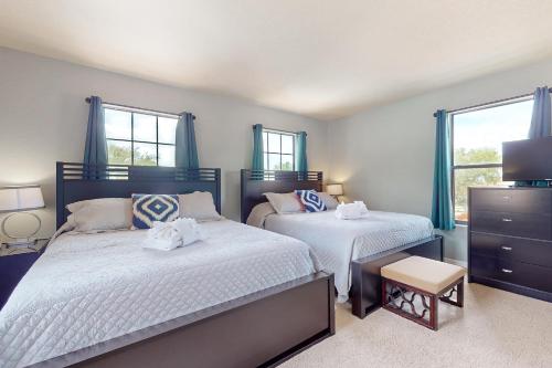twee bedden in een slaapkamer met twee ramen bij Summer's Place in Orlando