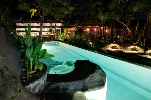 a swimming pool in a garden at night at Jicaro Island Lodge Member of the Cayuga Collection in Isletas de Granada