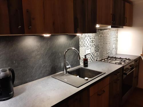 a kitchen with a sink and a stove at Ferienwohnungen im Griachalgarten - Chiemgau Karte in Inzell