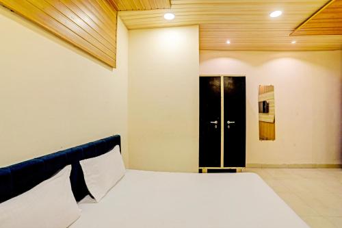 1 dormitorio con cama y puerta negra en OYO Hotel Rose Valley en Indore