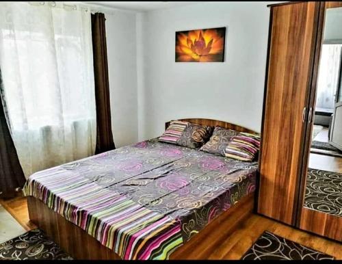 - une chambre avec un lit doté d'un cadre en bois dans l'établissement Casa Eva și Ioan, à Corbu