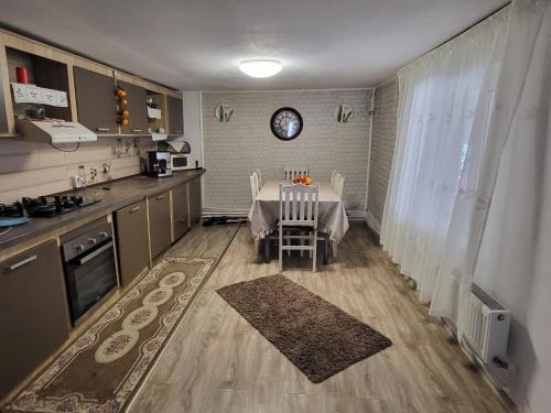 cocina con mesa con sillas y reloj en la pared en Casa Eva și Ioan, en Corbu