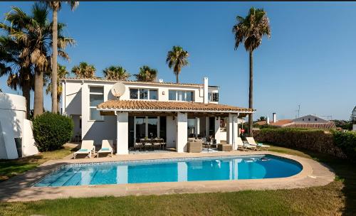 uma casa com piscina em frente a uma casa em Villa Roxana em Es Castell