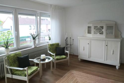 a living room with two chairs and a table and a cabinet at Helle 4 ZKB mit Balkon in Wittlich in Wittlich