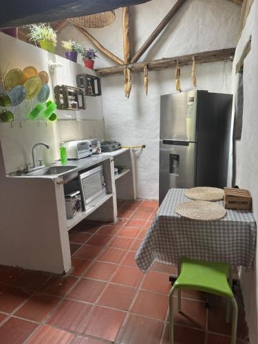 una pequeña cocina con mesa y nevera en CASITA CAMPESINA A 20 MIN DE SOGAMOSO, en Sogamoso
