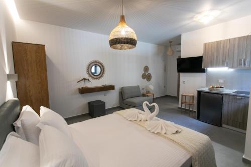 a bedroom with a white bed and a kitchen at Gaia Apartment II in Parga
