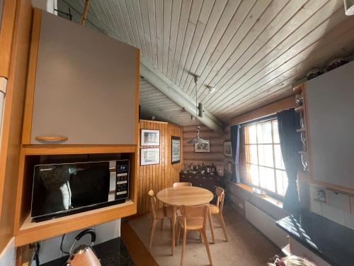 een keuken en eetkamer met een tafel en een magnetron bij Log home near Santa in Rovaniemi