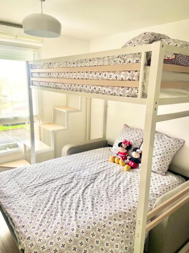 une chambre avec un lit superposé avec une échelle dans l'établissement Appartement élégant Disneyland, à Montévrain