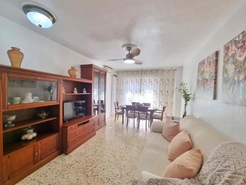 uma sala de estar com um sofá e uma sala de jantar em Segunda Linea de Playa, céntrico y equipado - by Aloha Palma em Águilas