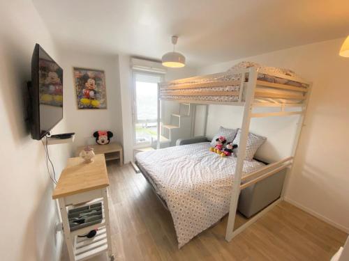 een slaapkamer met een stapelbed en een bureau bij Appartement élégant Disneyland in Montévrain