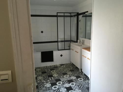 La salle de bains est pourvue de carrelage noir et blanc. dans l'établissement Chez Isa, au Mans