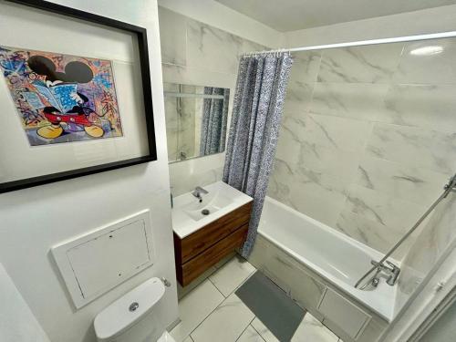 een badkamer met een toilet, een wastafel en een douche bij Appartement élégant Disneyland in Montévrain