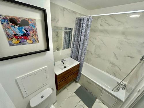 une salle de bain avec toilettes, lavabo et douche dans l'établissement Appartement élégant Disneyland, à Montévrain