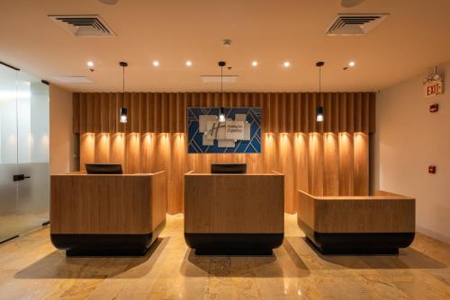 a lobby with two desks in front of a curtain at Hotel Holiday Inn Express & Suites Medellin, an IHG Hotel in Medellín