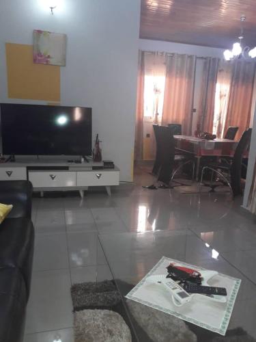 a living room with a flat screen tv and a table at appartement meublé à Yansoki douala in Ngori
