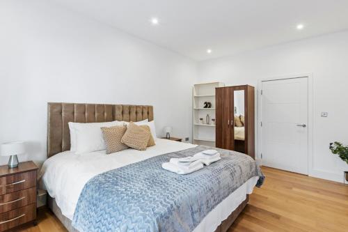 1 dormitorio con 1 cama con 2 toallas en Cozy One-Bedroom Retreat in Morden SM4, London en Morden