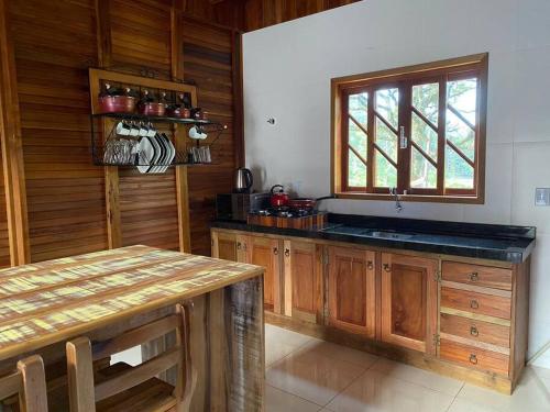 - une cuisine avec des placards en bois et un comptoir dans l'établissement Chalé Vô Vilbertinho, pousada com café da manhã!, à Alfredo Wagner