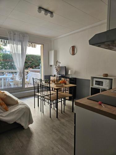 une cuisine et une salle à manger avec une table et des chaises dans l'établissement Le Goéland à 300 de la plage - 400m du centre ville, au Grau-du-Roi