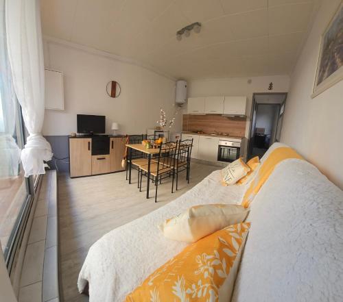 une chambre avec un lit et une cuisine avec une table dans l'établissement Le Goéland à 300 de la plage - 400m du centre ville, au Grau-du-Roi