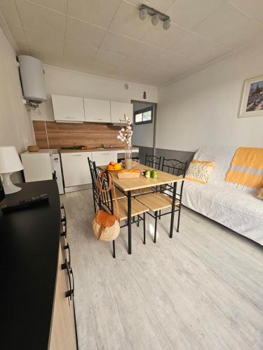 - un salon avec une table à manger et un lit dans l'établissement Le Goéland à 300 de la plage - 400m du centre ville, au Grau-du-Roi