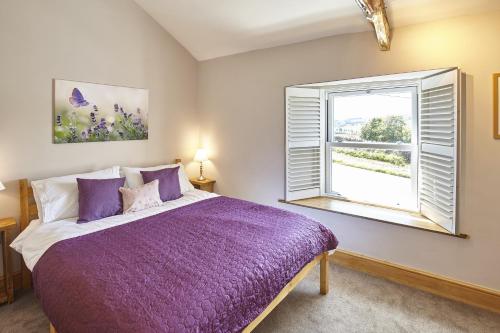 a bedroom with a purple bed and a window at Cumbria, en-suite bathrooms, North Pennines in Alston